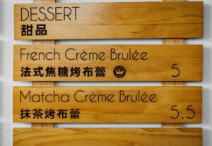 Board with food menu items in French and Mandarin